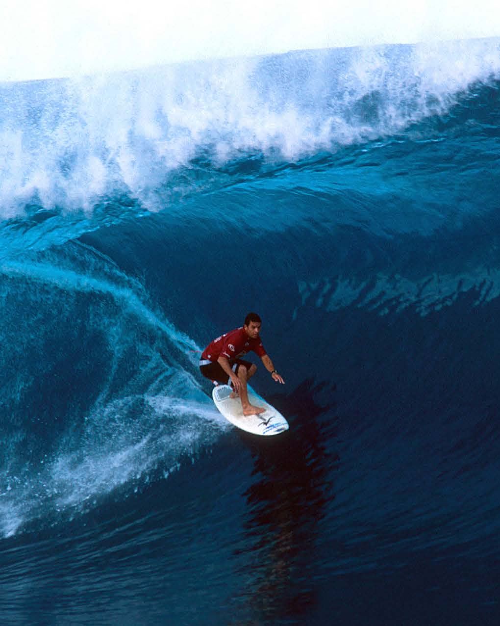 Surfer riding a large barrelling wave on an Aloha surfboard